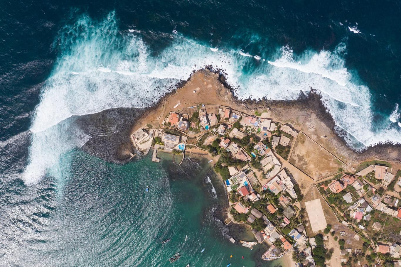 Vue aérienne d'un village côtier sénégalais entouré par l'océan